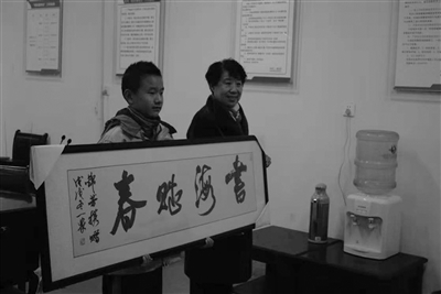 　陈锦芳老人特意请书法家写了幅“书海赋春”赠送给桂天生。校方供图