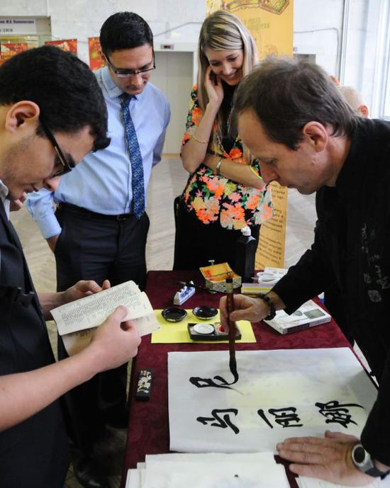 　2013年11月23日，在俄罗斯首都莫斯科，俄罗斯汉语书法家在庆祝莫斯科大学孔子学院成立5周年活动中挥毫泼墨。 （新华社）